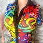 Colorful romper with abstract patterns, collar, and graphic script text on a mannequin against a neutral background