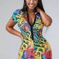 Woman wearing a colorful 90s theme romper with buttons against a plain background