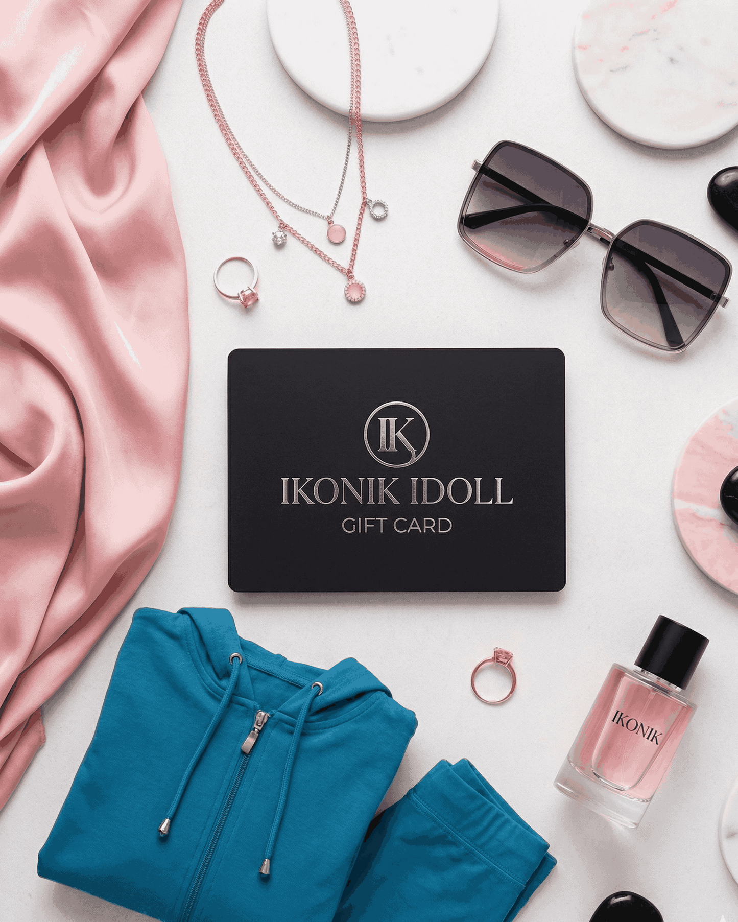 Ikonik Idoll gift card surrounded by fashion items on a white surface