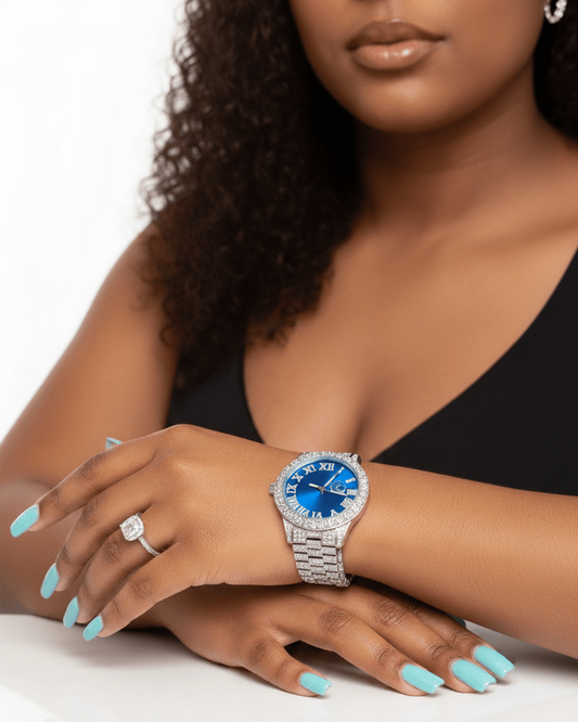 Woman wearing a silver watch with a blue face on a white background