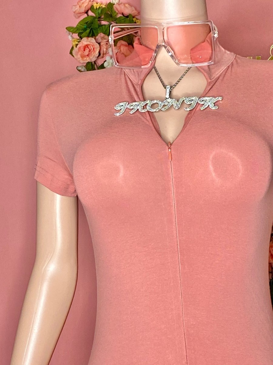 Mannequin wearing a pink outfit with sunglasses and a necklace against a pink background