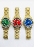 Three gold-iced out watches with green, red, and blue faces on a white background