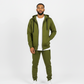 Front view of olive green men’s matching sweatsuit with white undershirt peeking out, clean minimal background.
