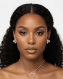 Woman wearing heart-shaped earrings and a necklace on a white background