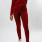 Model in burgundy two-piece tracksuit and burgundy and white Jordans on white studio backdrop