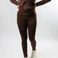 Model wearing a brown outfit for fall with white sneakers on a white background