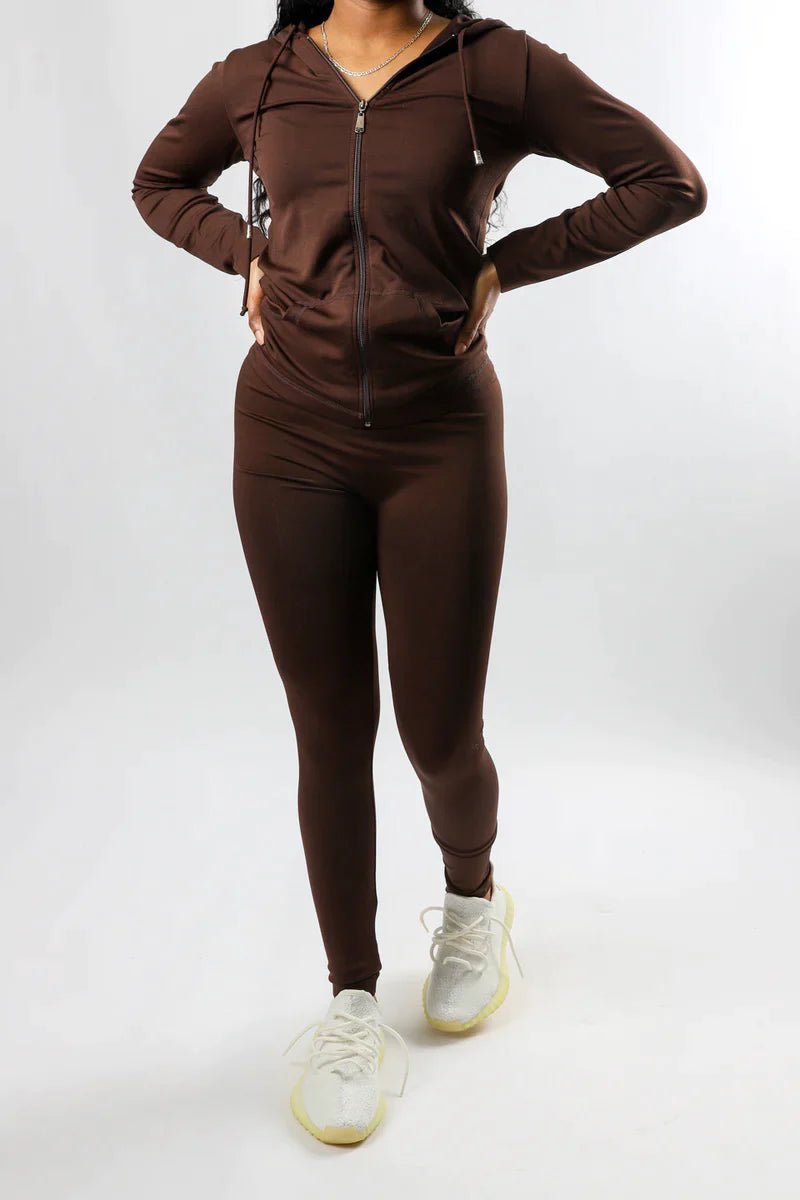 Model wearing a brown outfit for fall with white sneakers on a white background