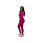 Woman in a pink matching legging outfit set and air force ones standing in a living room with pink decor