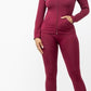 Plus-size model in burgundy two-piece leggings set styled with sneakers and bag for casual fall outfit