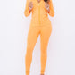 Neon orange leggings and jacket set styled with heels for plus-size women who love bold comfy outfits