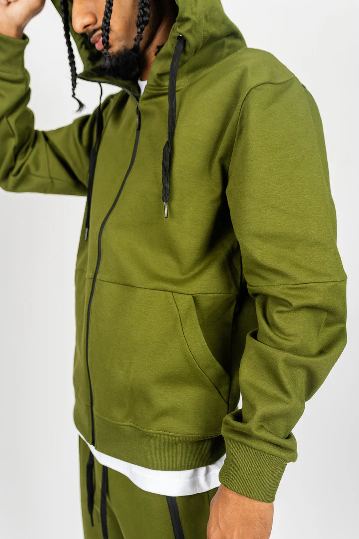 Close-up of olive green tech fleece material showing pocket zipper and fabric texture.
