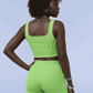 Person wearing a bright green sports outfit on a light blue background