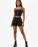 Woman wearing a black studded outfit on a white background