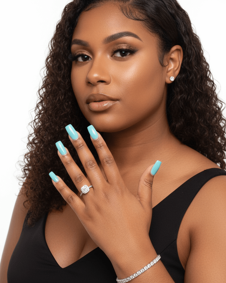 Woman showing off tennis bracelet and diamond ring with styled hair and turquoise nail polish wearing a black top on a white background