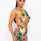 Woman wearing a colorful floral halter style romper on a white background