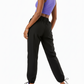 Woman wearing a purple crop top and black pants on a white background